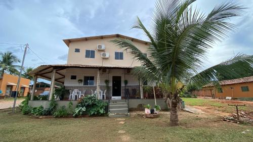 a house with a palm tree in front of it at Pousada Alma Jalapoeira - Mateiros in Mateiros