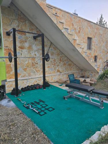 a gym with a bench and a table at Cortina House Berat in Kuçovë