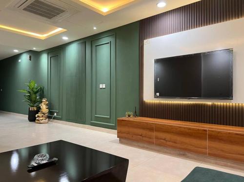 a living room with a large flat screen tv on a wall at Gold Crest Mall Prestigious Suites with Balcony by CityScape in DHA Lahore in Lahore