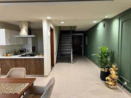 a kitchen and a dining room with green walls at Gold Crest Mall Prestigious Suites with Balcony by CityScape in DHA Lahore in Lahore