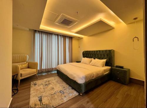 a bedroom with a bed and a couch and a chair at Gold Crest Mall Prestigious Suites with Balcony by CityScape in DHA Lahore in Lahore