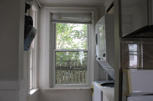a kitchen window with a view of a tree at Witch City Retreat with Tiki Bar in Downtown Salem in Salem