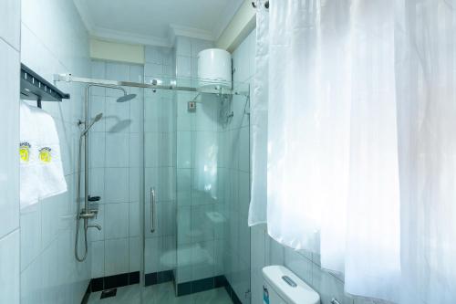 Un baño con ducha de cristal y un inodoro. en Goshen Luxury Apartment C1, en Kampala