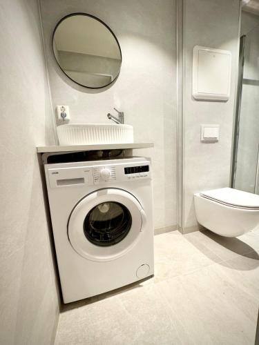 a washing machine in a bathroom with a mirror at Bright & Cozy Studio - Central Location in Oslo