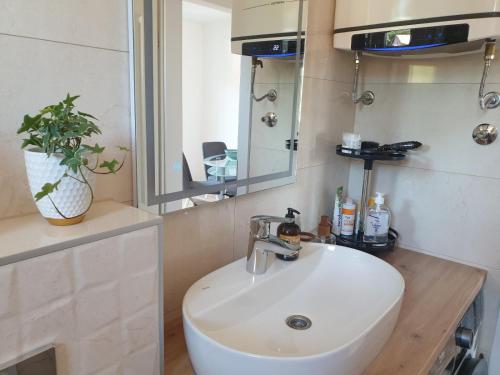 a bathroom with a white sink and a mirror at City Vibe Apartment in Tuzla