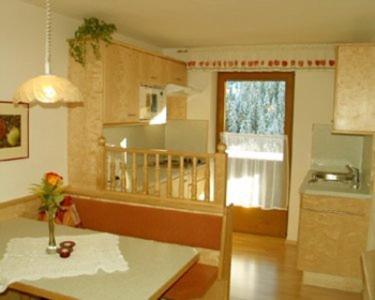 a living room with a table and a kitchen at Gästehaus Elfriede in Gerlos