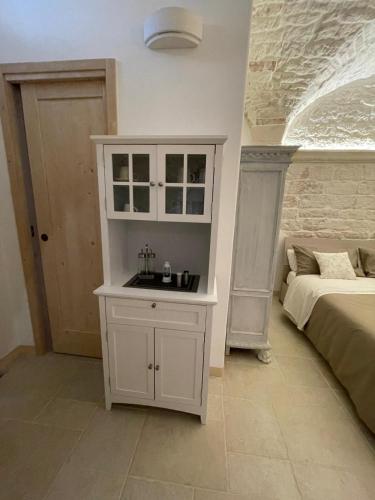 a bedroom with a white cabinet next to a bed at L'hammam tra le volte a stella in Ceglie Messapica