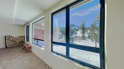 a room with windows with a view of a mountain at Comfortable Condo - Gorgeous Slopeview and Access to 3 Hot Tubs Unit 303 at 1849 in Mammoth Lakes