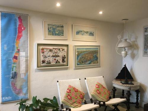 a room with two chairs and pictures on the wall at Pousada Casa do Bicho Preguiça in Angra dos Reis