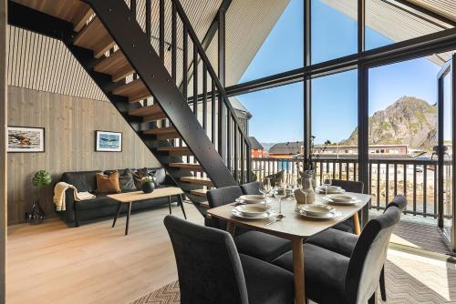 a dining room with a table and chairs and a large window at Rorbuleilighet Lysøysundet 1G in Henningsvær