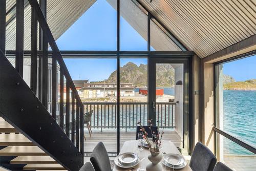 a dining room with a view of the water at Rorbuleilighet Lysøysundet 1G in Henningsvær