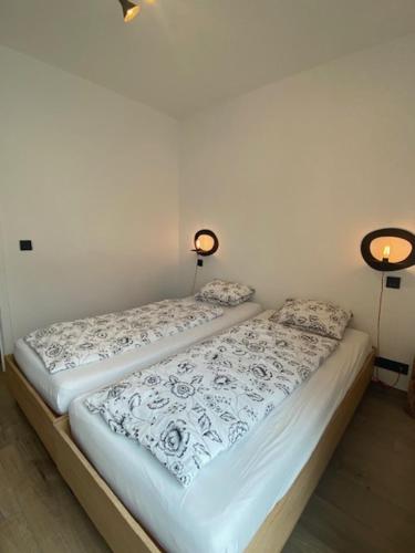 two beds sitting next to each other in a room at Vakantiewoning Petit Watou in Poperinge