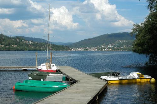 three boats are docked at a dock on a lake at Maison La Devinière - sauna et spa compris accessibles toute l'année in Xonrupt-Longemer