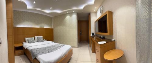 a hotel room with a bed and a television at فندق الملك - King Hotel in Karbalāʼ