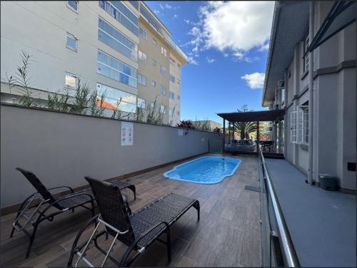 un patio con sillas y una piscina en un edificio en Pousada Casarão Schmidt, en Pomerode