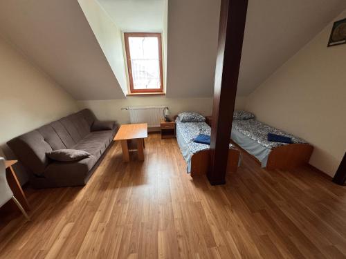 a living room with a couch and a table at Dom Pielgrzyma - Sanktuarium Matki Bożej Leśniańskiej in Leśna Podlaska