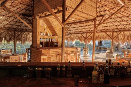 a bar in a wooden building with bottles of wine at Hotel isla bonita in Tintipan Island