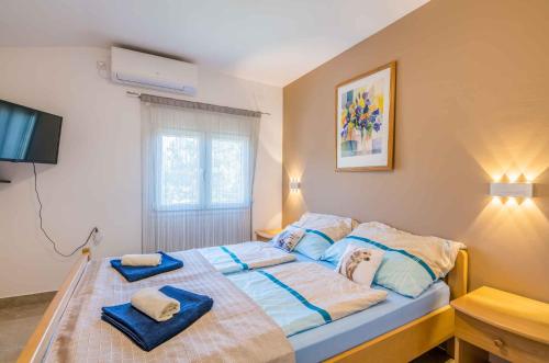 a bedroom with a large bed with towels on it at Apartment in Cizici - Insel Krk 12512 in Čižići