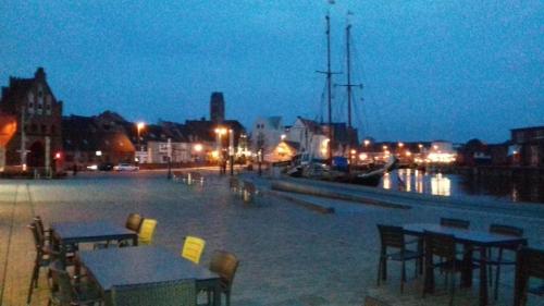 a view of a harbor at night with tables and chairs at Simple Mini- Apartment City Park in Wismar