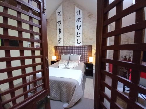 a room with a bed and a door with a sign at Aux quatre coins du monde in Champvoux