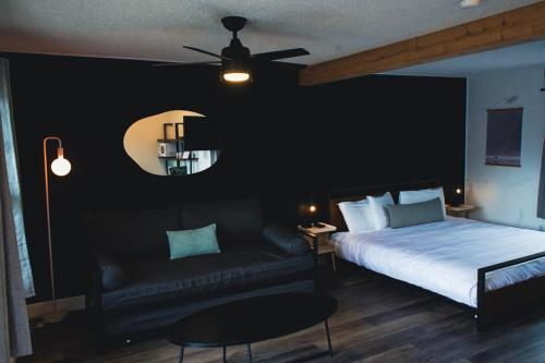 a bedroom with a bed and a couch and a ceiling fan at The Spinn in Manzanita