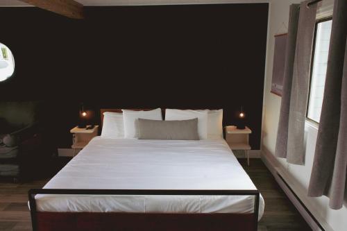 a bedroom with a large white bed with black walls at The Spinn in Manzanita