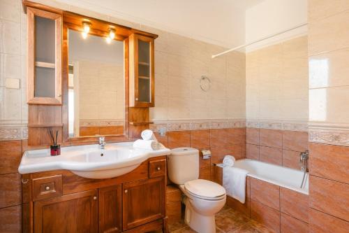 a bathroom with a sink and a toilet and a tub at Lassi Seaview Villa Private Pool Villa Efrosini Short Walk To Resort Centre in Kefallonia