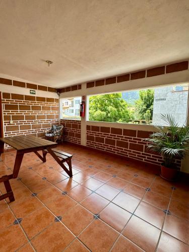 a room with a table and a brick wall at Hospedaje Teponaztle in Tepoztlán