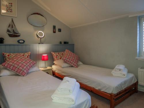 two twin beds in a room with a window at Ivy Cottage in Aldeburgh