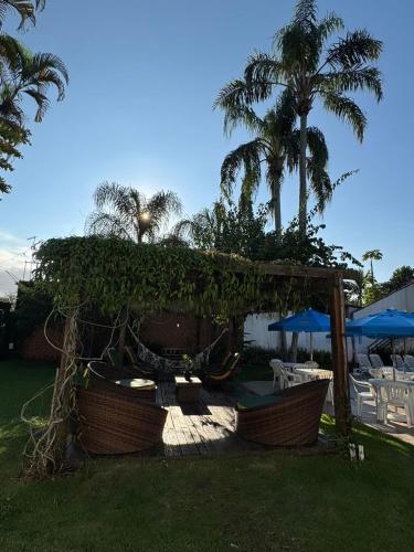 a gazebo with chairs and umbrellas in a yard at Pousada Point Beach - Acácias in Guarujá