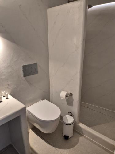 a white bathroom with a toilet and a sink at Koko Room's 1 in Kithnos