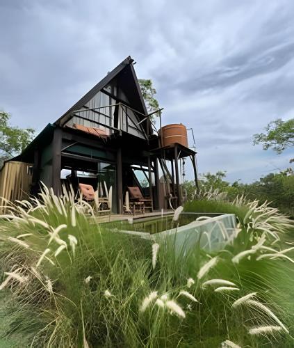 a house sitting on top of a lush green field at Espaço Gaia in Santana do Riacho
