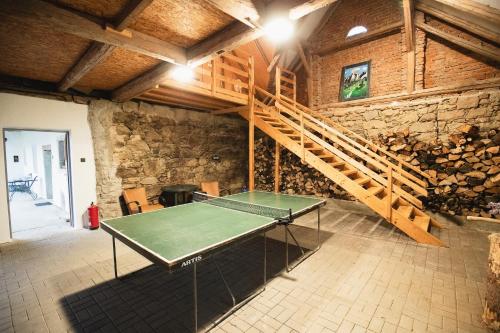 a ping pong table in a room with a staircase at Chalupa Jilem in Jilem