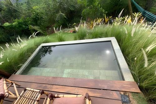 a large glass window in a garden with grass at Espaço Gaia in Santana do Riacho