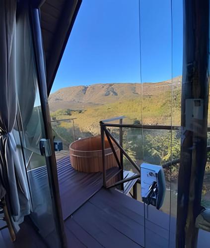 a balcony with a tub and a view of a mountain at Espaço Gaia in Santana do Riacho