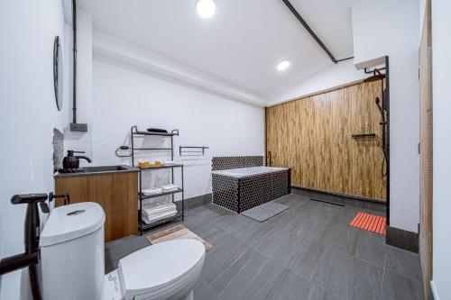 a bathroom with a toilet and a wooden door at Oasis Suites Pattaya in Pattaya Central