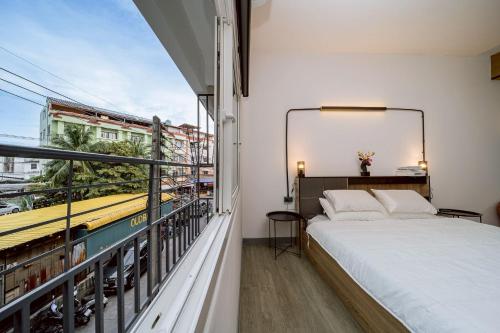 a bedroom with a bed and a balcony at Oasis Suites Pattaya in Pattaya Central