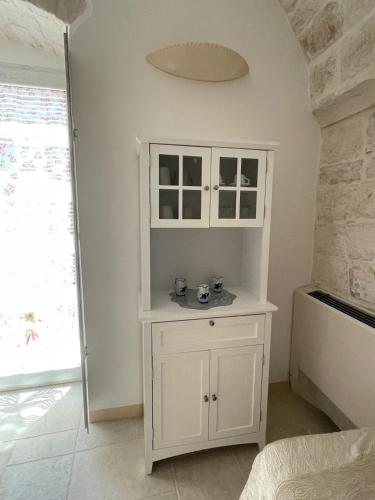 a white cabinet in a room with a window at L'hammam tra le volte a stella in Ceglie Messapica