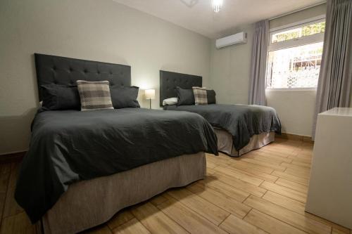 a bedroom with two beds and a window at In & Out Hotel in Guatemala
