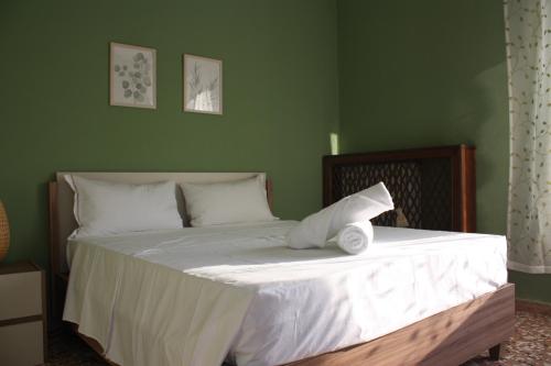 a green bedroom with a bed with white sheets and pillows at Bridge To Venice in Venice