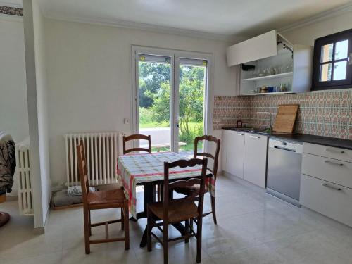 une cuisine avec une table et des chaises et une fenêtre dans l'établissement Ty Denise, à La Celle-sous-Gouzon