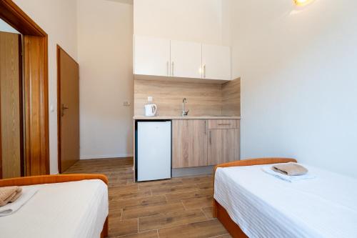a small kitchen with two beds and a refrigerator at Gabriel in Neum