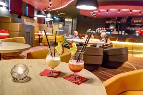 two cocktails sitting on a table in a restaurant at AIGO Welcome Family Resort in Aigen im Mühlkreis