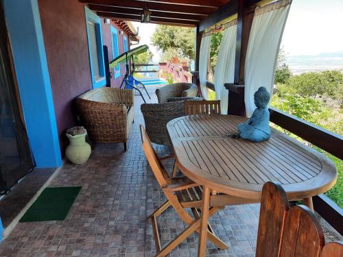 a teddy bear sitting on a wooden table on a porch at Villa Veronica in Sedini