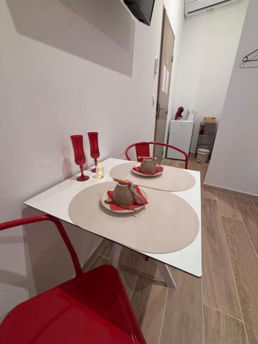 - une table blanche avec deux chaises et deux verres dans l'établissement La Rubis, à Narbonne