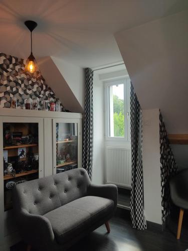 a living room with a couch and a window at Au P'tit Versailles in Châtillon-sur-Seine