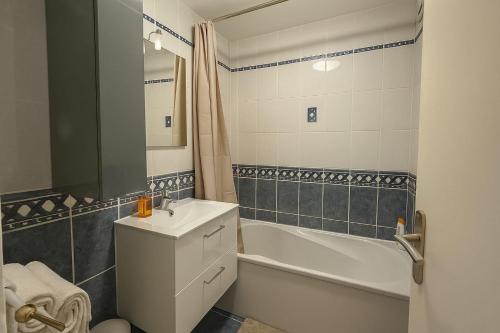 une salle de bain avec un lavabo, une baignoire et des toilettes dans l'établissement Feel at Home Between Paris and Disneyland, à Champs-sur-Marne