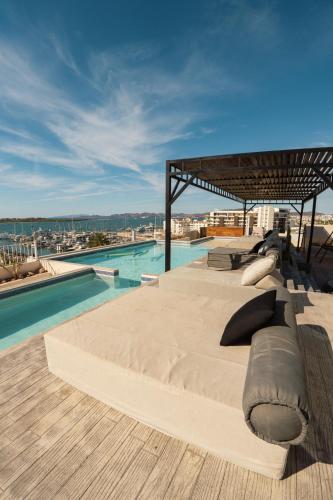 a bed with pillows on it next to a pool at Style and confort by Porto Vacanze at Laiva in La Paz