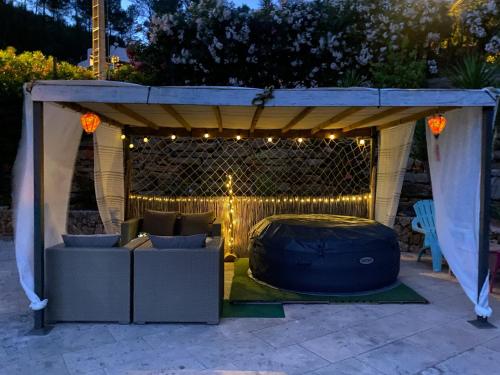 a gazebo with a couch under it with lights at Villa 3ch piscine vue dégagée in Taradeau