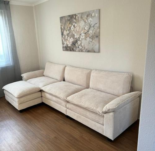 a white couch sitting in a living room at C&V 4 Personen 3 Zimmer Central Smart TV Boxspringbett in Kaiserslautern
